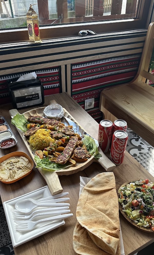 Table at Kebab Habibi set with a grill platter, hummus, salad and flatbread